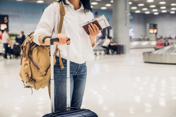 Havalimanında pasaport ve bilet tutan sırt çantalı kadın