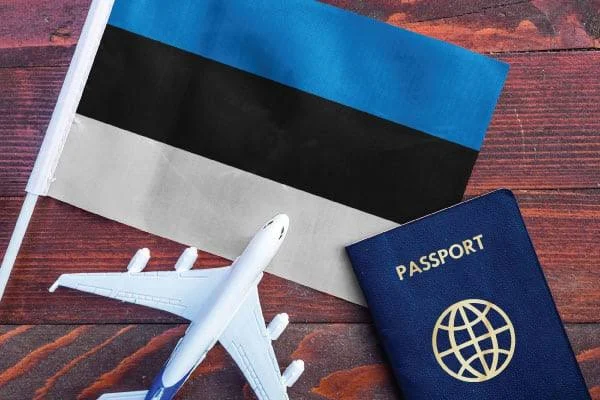 masanın üstünde estonya bayrağı maket uçak ve estonya pasaportu